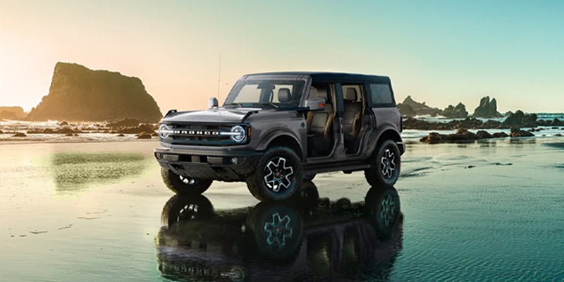 brand new gray 2023 Ford Bronco without doors on sitting on the the beach by the waters edge near Madison Ford.